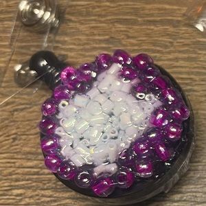 White and purple sea glass details on a self retracting ID badge